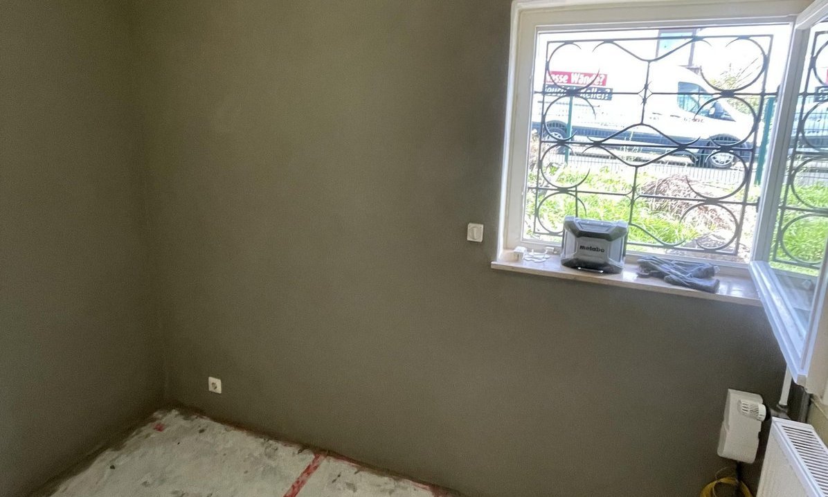 Zimmer mit Fenster, Wandfläche mit grauer Masse beschichtet, Boden mit Abdeckvlies geschützt