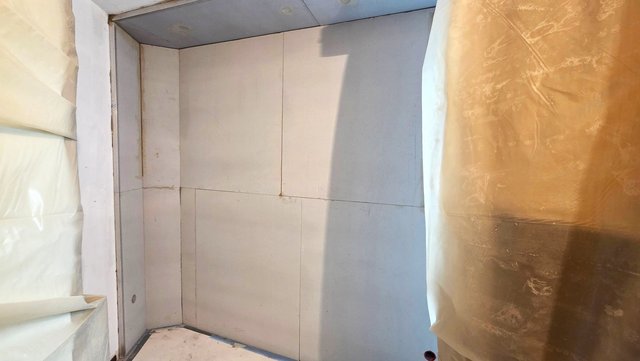 Helle Platten an Wand und Decke, Arbeitsbereich mit Schutzfolie abgedeckt