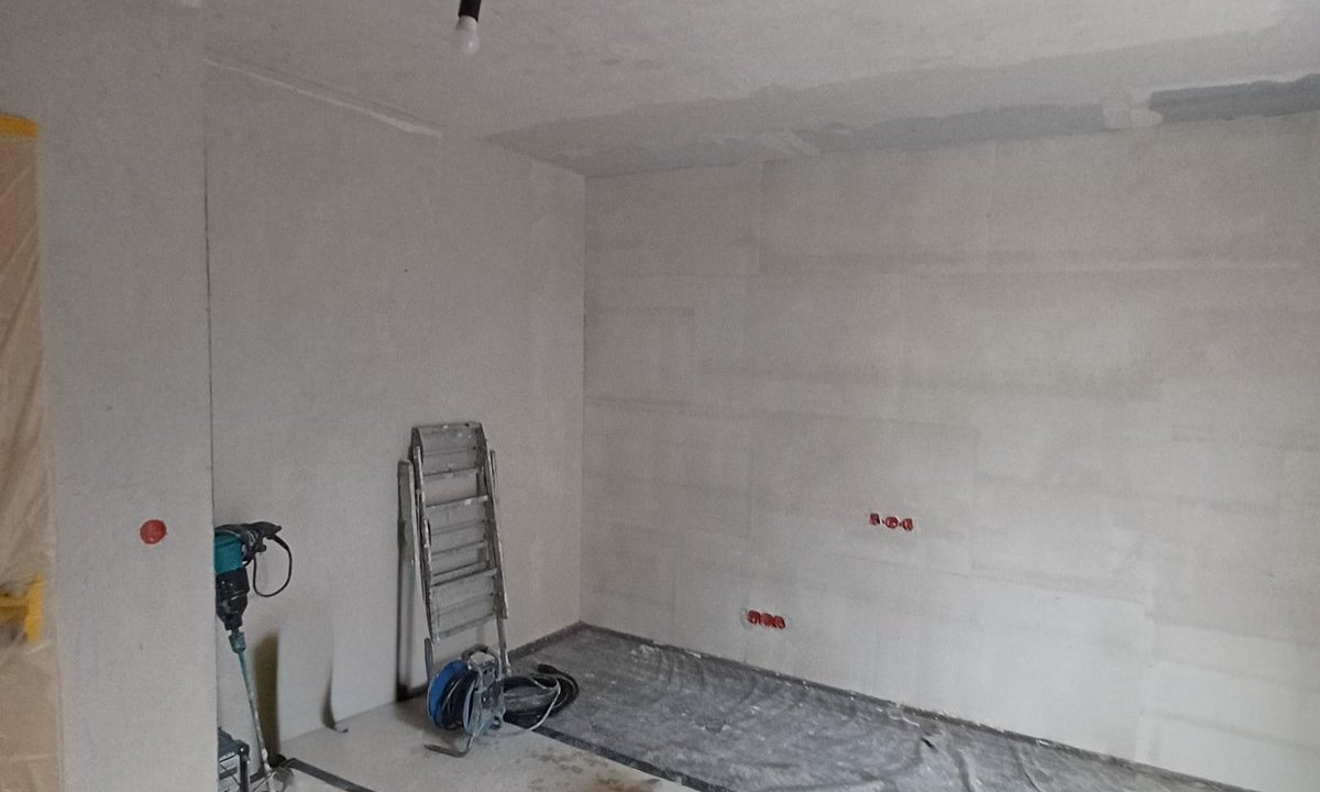 Unfertiger Raum mit Werkzeug und abgedecktem Boden