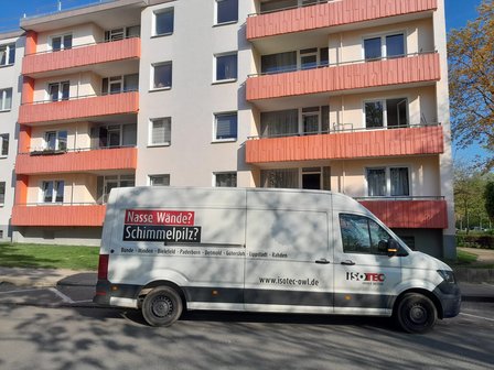 ISOTEC Transporter vor Mehrfamilienhaus mit Balkonen