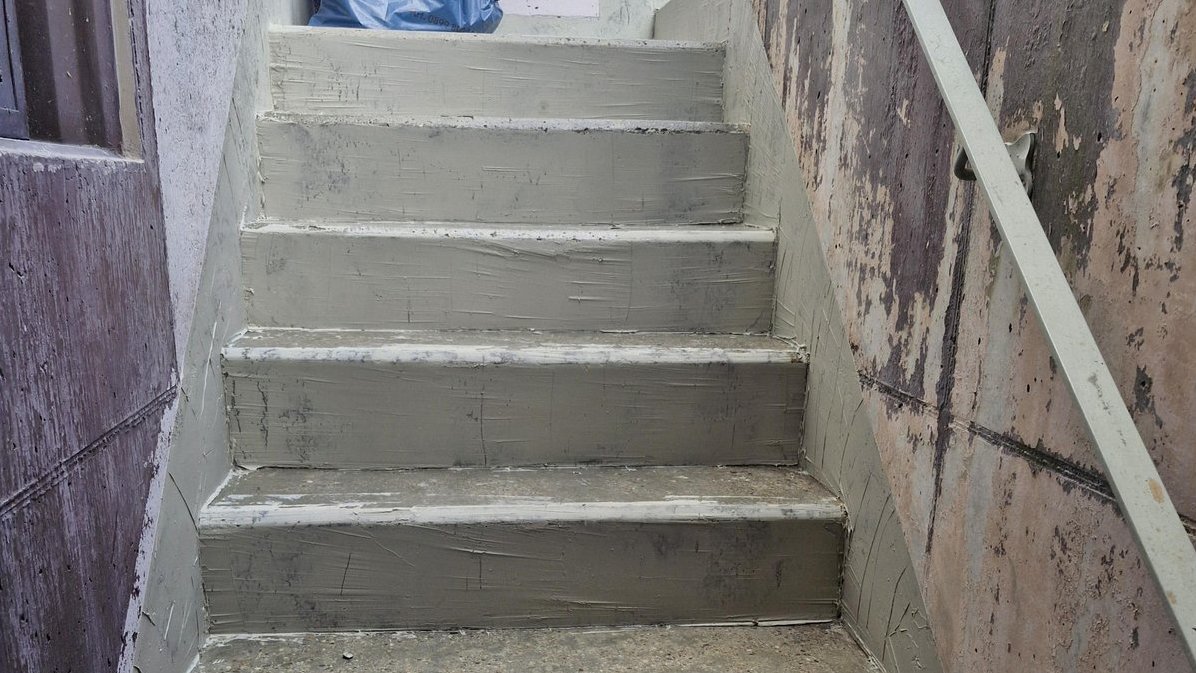 Betontreppe mit grauer Masse an Stufen und Seitenwänden, Nahaufnahme