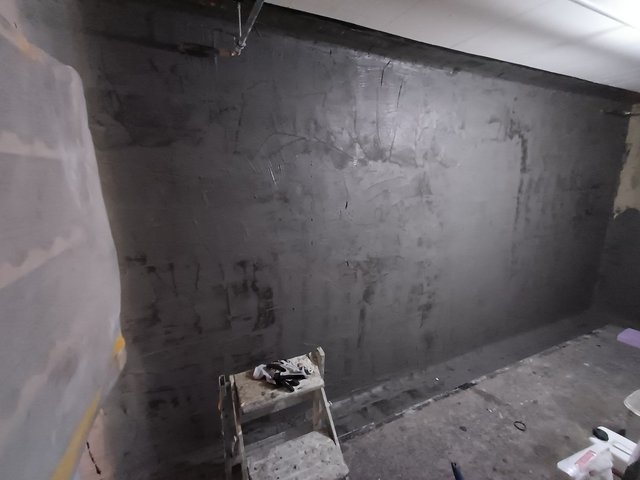 Schwarze Masse auf Kellerwand, Gesamtansicht
