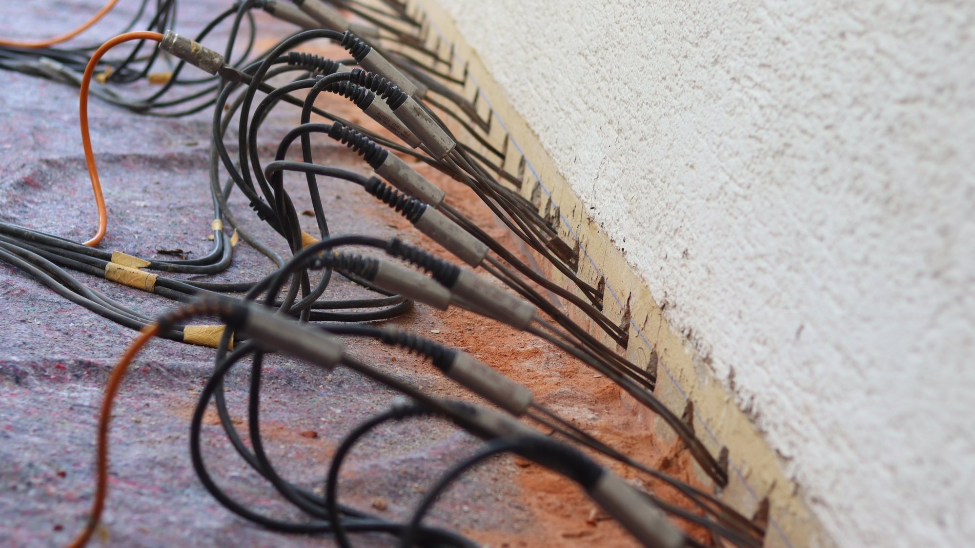 Messsonden stecken in Bohrlöchern am Wandfuß, Nahaufnahme