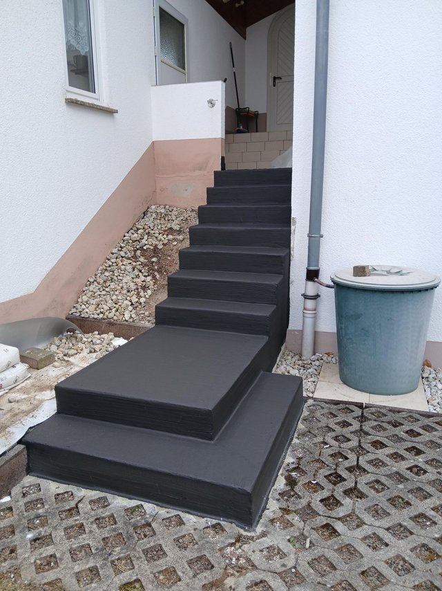 Schwarze Beschichtung auf Außentreppe und Podest am Hauseingang