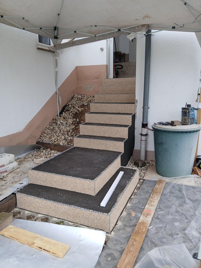 Neu verkleidete Außentreppe mit Steinstufen unter Schutzdach