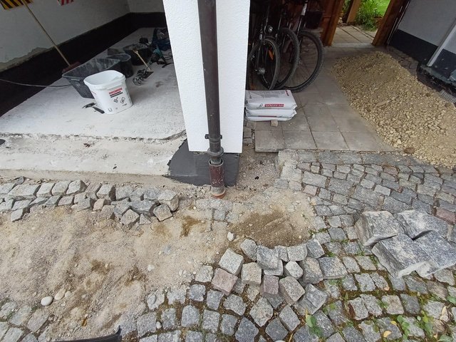 Aufgenommene Pflastersteine und freigelegter Kiesbereich vor Hauseingang