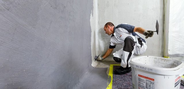 Spezialist bei der Arbeit an einer Kellerinnenwand, um eine effektive Kellerabdichtung zu gewährleisten