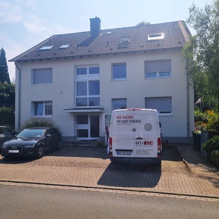 ISOTEC Fahrzeug vor mehrstöckigem Wohnhaus geparkt.