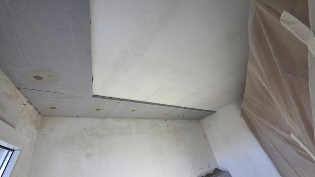 Helle Platten an Decke montiert, Wand und Decke mit dunklen Verfärbungen