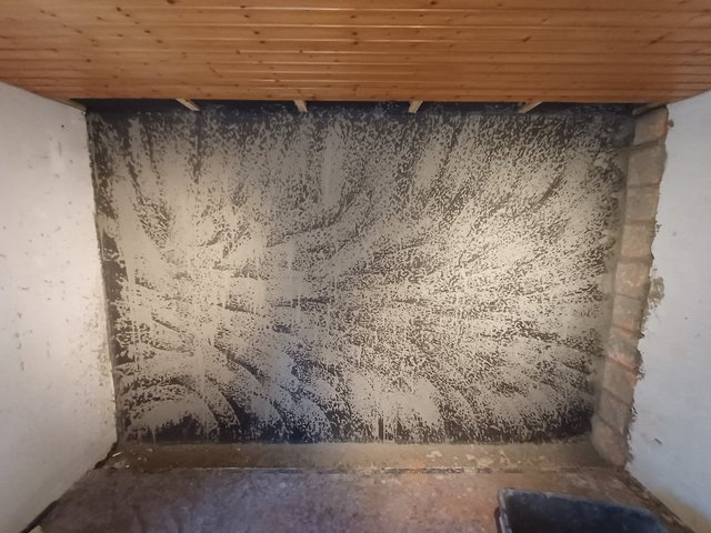 Schwarze und helle Masse auf Wand unter Holzdecke