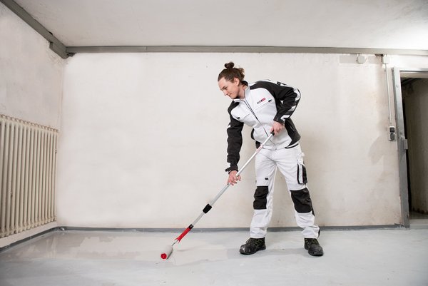 ISOTEC Facharbeiter trägt Schutzschicht auf Kellerboden auf zur Abdichtung gegen Feuchtigkeit