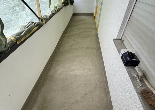 Grauer Bodenbelag auf Balkon, frisch geglättet