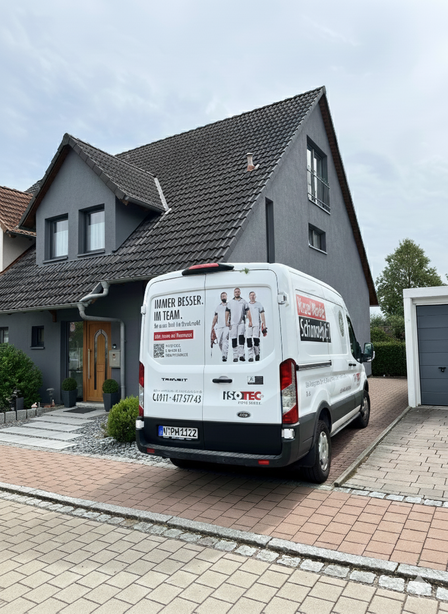 ISOTEC Transporter steht vor modernem Wohnhaus