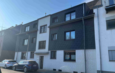 Reihenhausfassade mit dunkler Schieferverkleidung und weißen Klinkersteinen