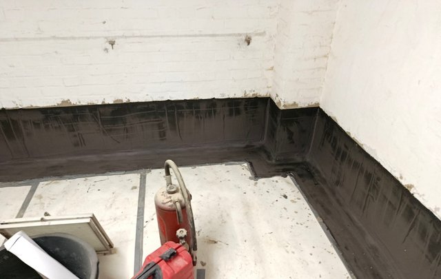 Schwarze Masse an Kellerwand und Bodenrand aufgetragen, Raumansicht