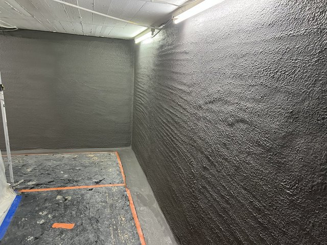 Schwarze Masse auf Kellerwänden, Raumansicht nach Beschichtung