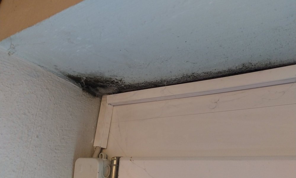 Schwarze Beläge an Wand über Türrahmen