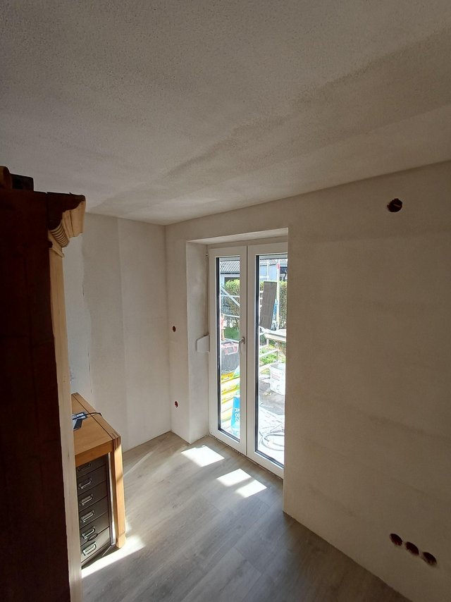 Heller Raum mit Fenstertür und großflächiger Verfärbung an der Decke