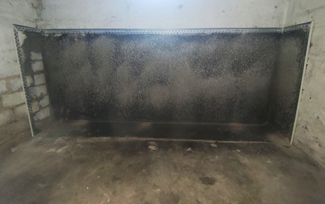Schwarze Masse auf Kellerwand, Frontalansicht