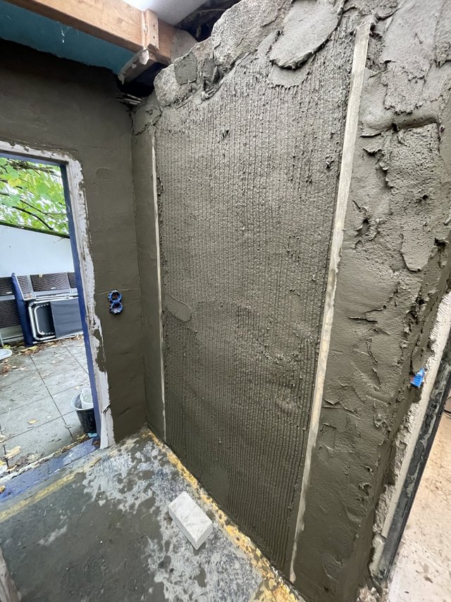 Wand mit grauer Masse beschichtet und gekämmt, Blick durch Türöffnung zur Terrasse