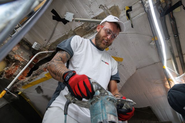 ISOTEC Mitarbeiter bohrt mit Elektrohammer in Betondecke, Baustelle im Keller