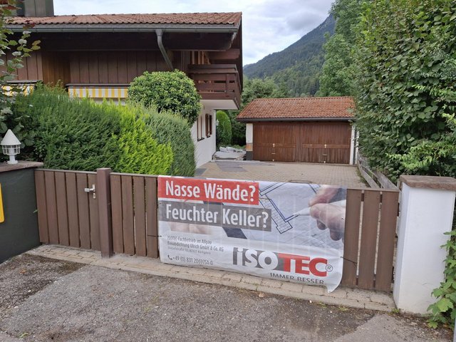 ISOTEC Werbebanner am Gartentor vor Wohnhaus und Garage
