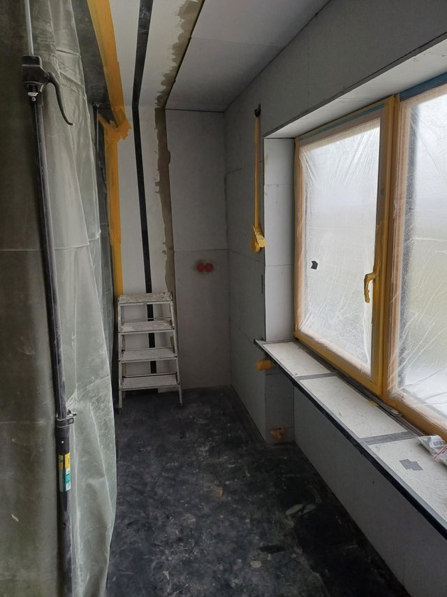 Raum mit hellen Platten und abgeklebt­em Fenster während Renovierung