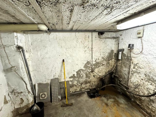 Feuchte Kellerwände mit dunklen Flecken an Decke und Bodenbereich