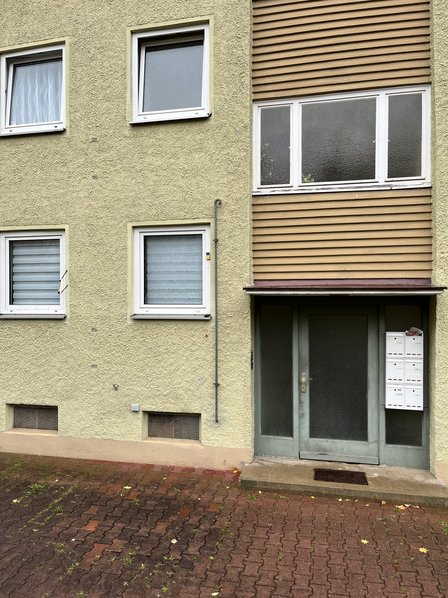 Hausfassade mit Eingangstür, Fenstern und Briefkästen