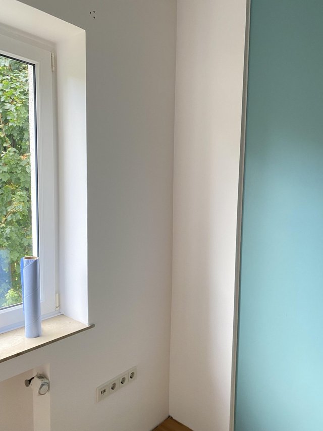 Weiße Zimmerecke neben Fenster mit Steckdosen und Fensterbank, Innenraum