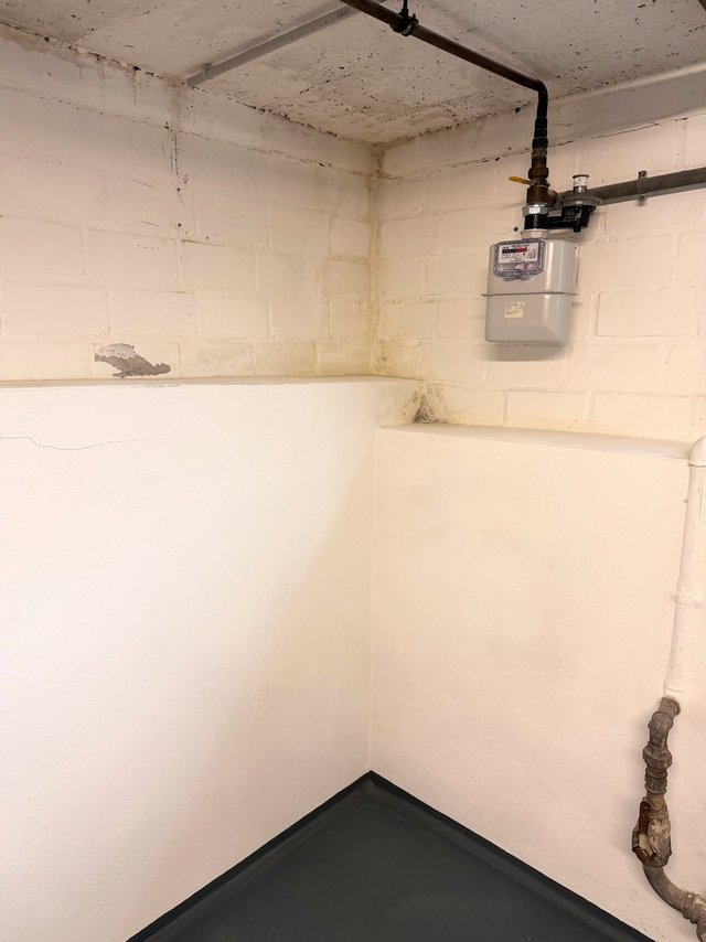 Kellerraum mit Gaszähler, Rohren und Verfärbungen an Decke und Wand