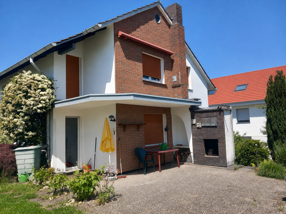 Zweistöckiges Einfamilienhaus mit Klinkerfassade, Terrasse und Gartenmöbeln