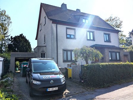 ISOTEC Fahrzeug vor Wohnhaus mit heller Putzfassade und Satteldach