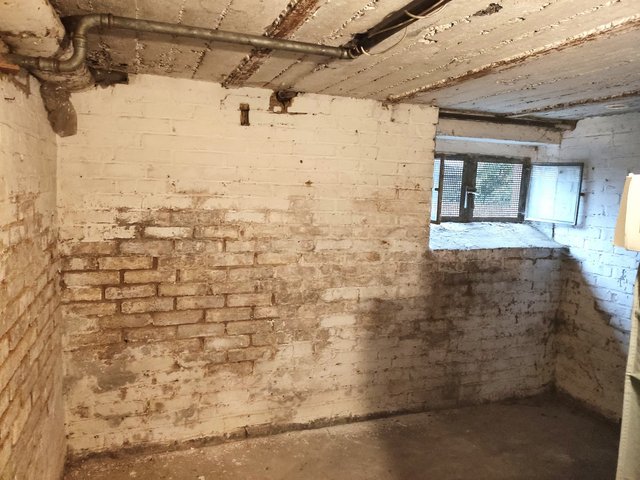 Feuchte Kellerwände aus Ziegelmauerwerk mit Flecken und Abplatzungen