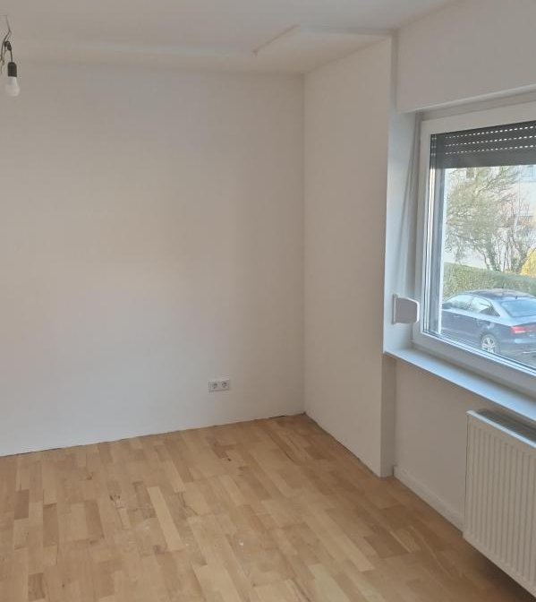 Leerer Raum mit weißer Wand, Holzfußboden und Fenster