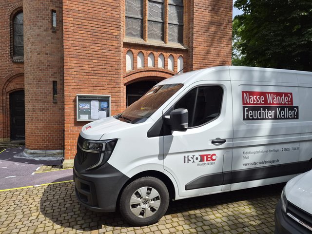 ISOTEC Transporter vor Backsteingebaeude mit Hinweis auf nasse Waende und feuchten Keller
