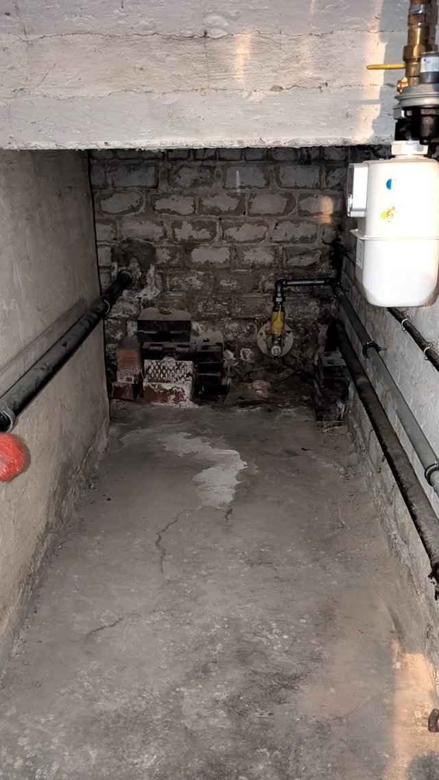 Feuchter Kellerboden mit Riss und Mauerwerk im Kriechkeller
