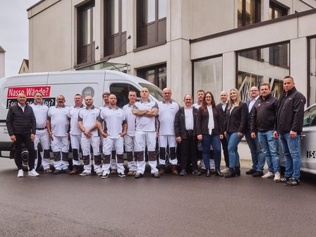 ISOTEC Team steht vor Firmenfahrzeug