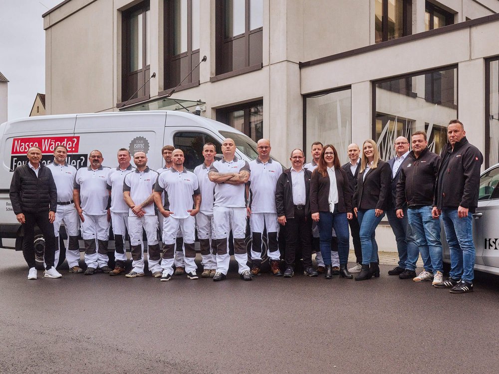 ISOTEC Team steht vor Firmenfahrzeug