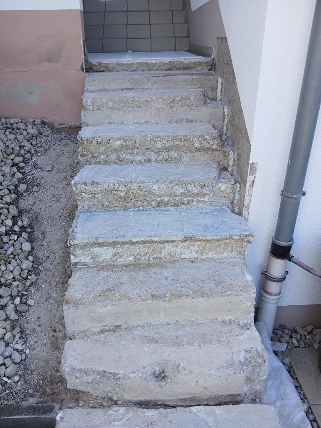 Beschädigte Betontreppe am Hauseingang, Frontalansicht