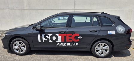 Schwarzer ISOTEC Firmenwagen mit großem Logo an der Fahrzeugseite, Seitenansicht.
