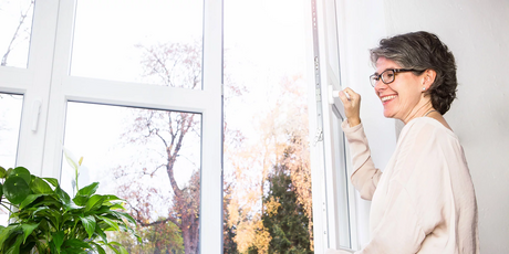 Frau lüftet Wohnung durch