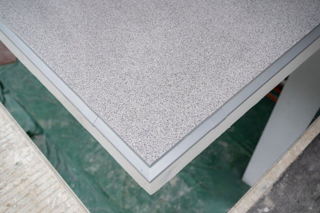 Helle gesprenkelte Platte mit grauem Kantenschutz, Nahaufnahme