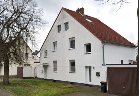 Weißes Wohnhaus mit rotem Ziegeldach und Garage, Straßenansicht