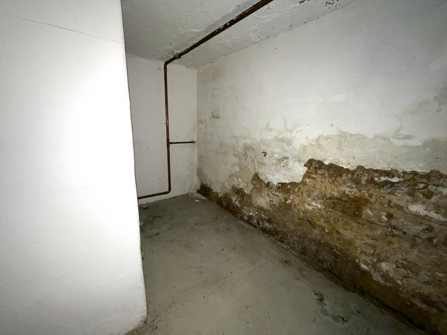 Feuchtegeschädigte Kellerwand mit bröckelndem Wandmaterial