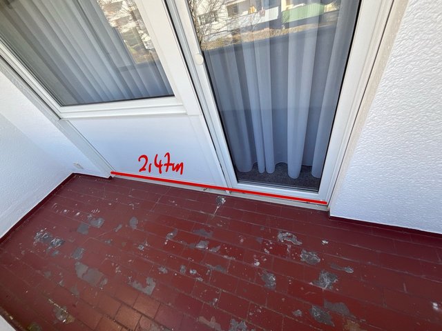 Balkontuer mit rotem Bodenbelag und Markierung 2,47 m