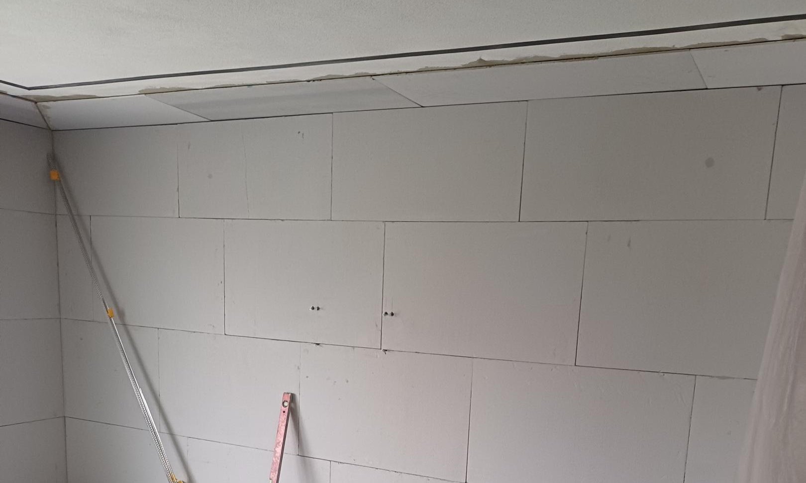 Baustellenraum mit montierten hellen Platten und abgestellten Werkzeugen