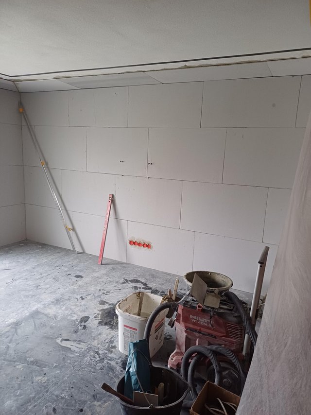 Baustellenraum mit montierten hellen Platten und abgestellten Werkzeugen