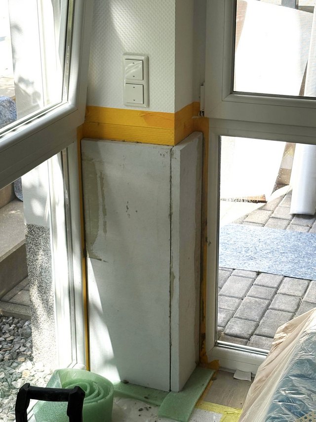 Abgeklebte Fensterecke mit heller Platte an Wand, Baustellenschutz am Boden