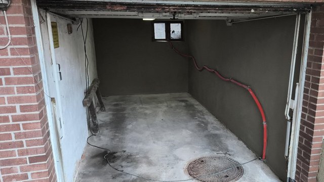 Kellerraum mit frischem Estrichboden und fleckiger Wand